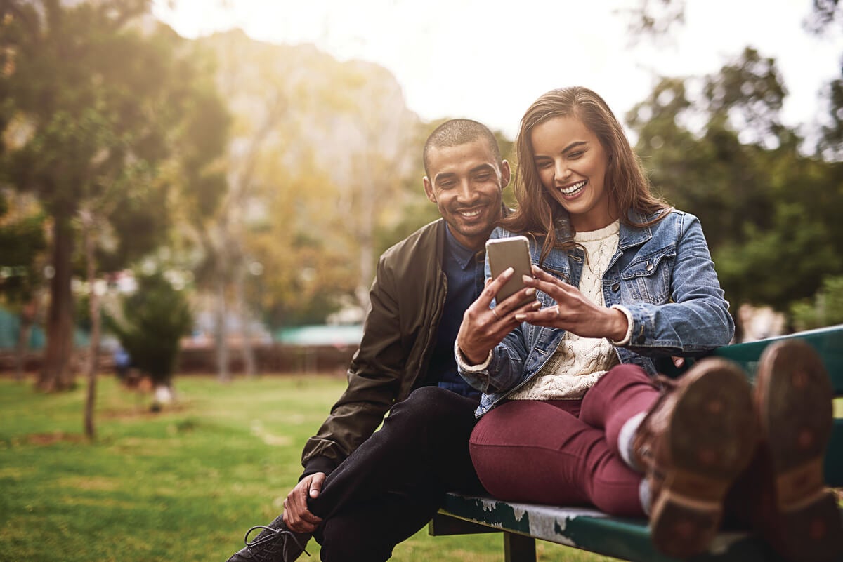 Couple looking at their direct deposited funds on their phone.