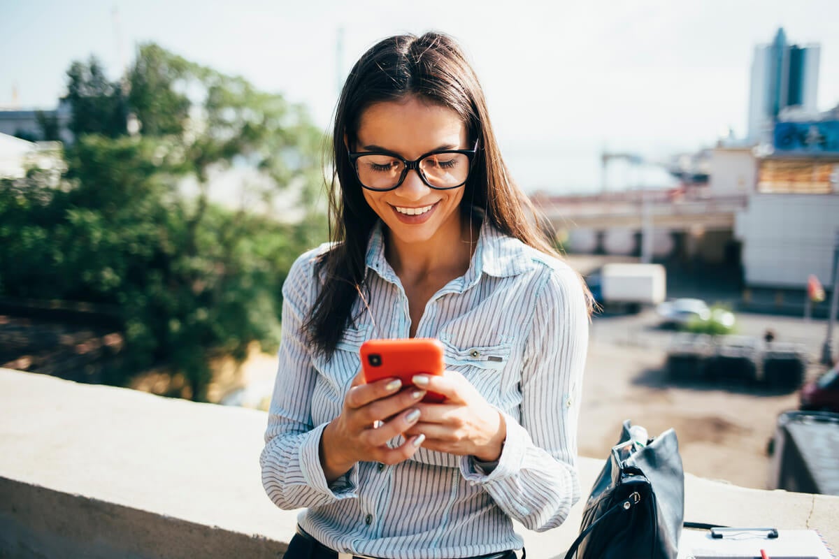 Woman looking at budgeting apps on her phone.